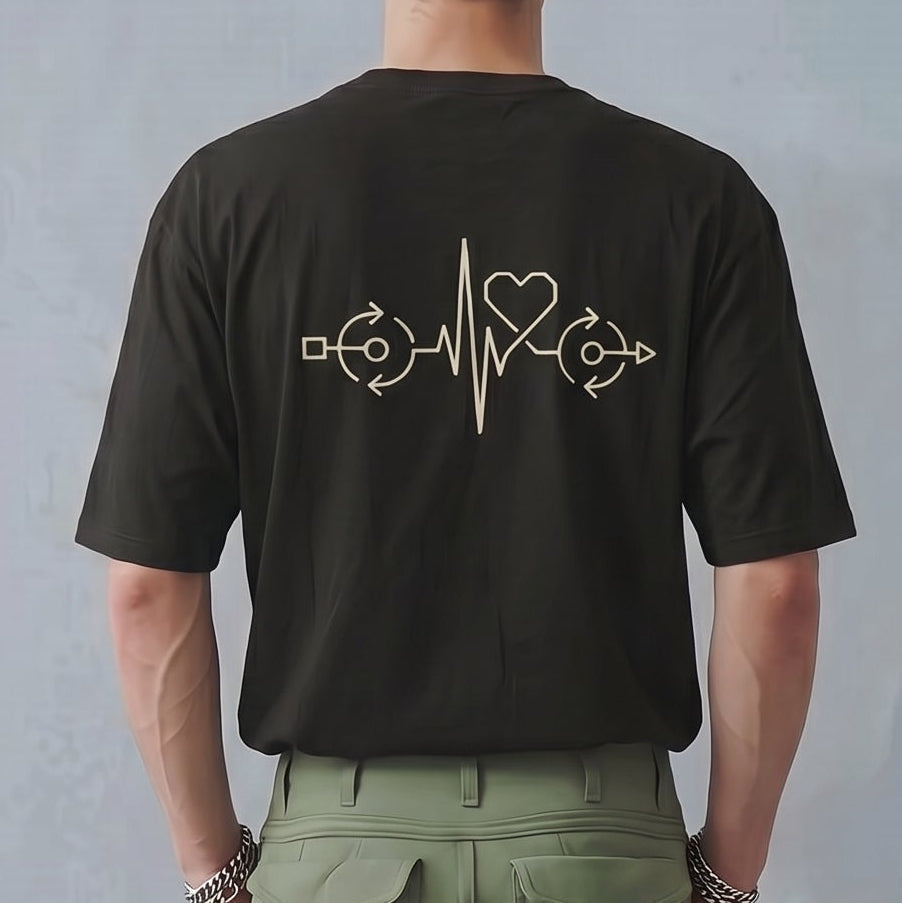 Person wearing a black t-shirt with a design on the back and green cargo pants against a plain background