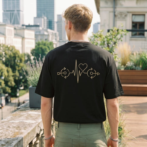 Person wearing a black t-shirt with a design on the back, standing on a rooftop with cityscape in the background